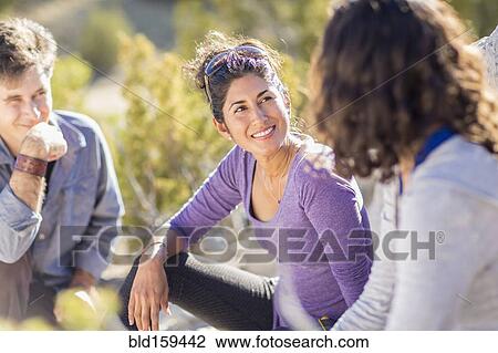 Stock Image - Close up of hikers talking outdoors. Fotosearch