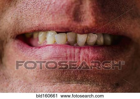 Stock Image - Close up of lips of Caucasian man grimacing. Fotosearch