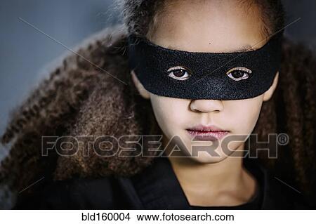 Picture - Close up of mixed race girl wearing mask. Fotosearch