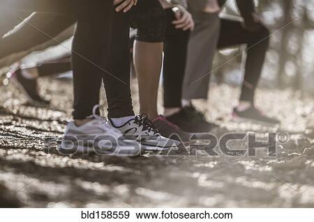 Close up of runners stretching in a row View Large Photo Image Stock Photo - Close up of runners stretching in a row. Fotosearch
