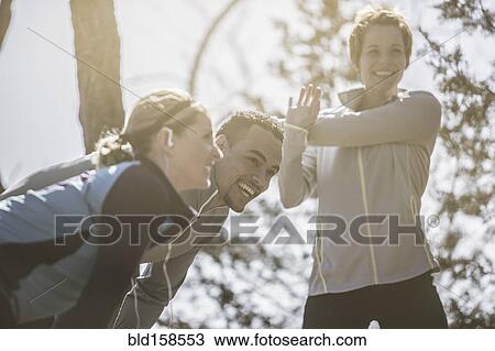 Stock Image - Close up of smiling athletes stretching. Fotosearch