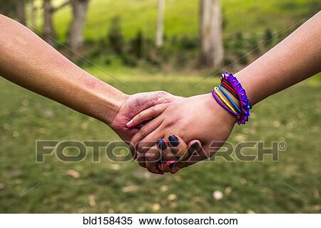 Close up of women holding hands in park View Large Photo Image Stock Photography - Close up of women holding hands in park. Fotosearch