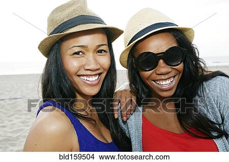Picture - Close up of women smiling on beach. Fotosearch