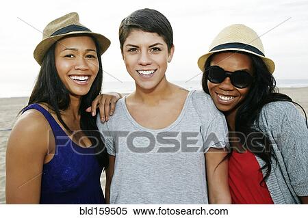 Stock Photography - Close up of women smiling on beach. Fotosearch