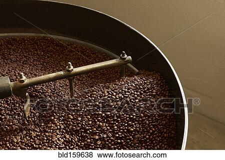 Stock Photo - Coffee beans roasting in industrial kettle. Fotosearch