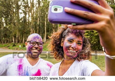 Couple taking selfie covered in pigment powder View Large Photo Image Stock Image - Couple taking selfie covered in pigment powder. Fotosearch