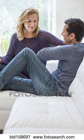 Stock Photo - Couple talking on living room sofa. Fotosearch