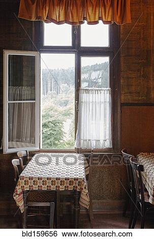 Stock Photograph - Empty tables near open window in cafe. Fotosearch