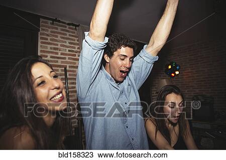 Stock Image - Friends cheering in nightclub. Fotosearch