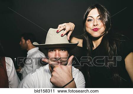 Stock Image - Friends smiling and playing in nightclub. Fotosearch