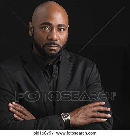 Stock Photo - Frowning black businessman with arms crossed. Fotosearch