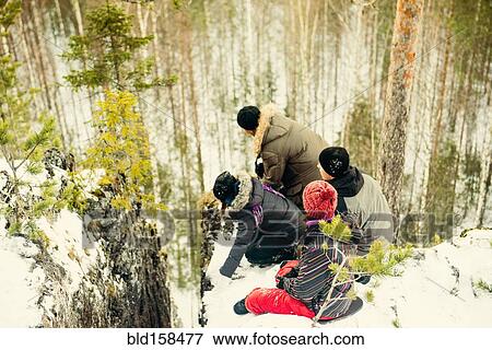 Stock Photo - High angle view of Caucasian hikers at the edge of cliff. Fotosearch