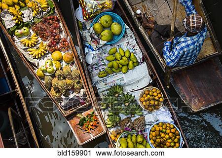 Stock Image - High angle view of merchant selling fruit in canoe. Fotosearch