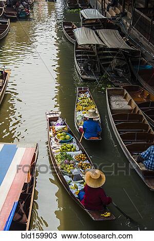 Stock Image - High angle view of merchants selling fruit in canoes. Fotosearch