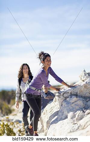 Hikers climbing rocky hillside View Large Photo Image Stock Photo - Hikers climbing rocky hillside. Fotosearch