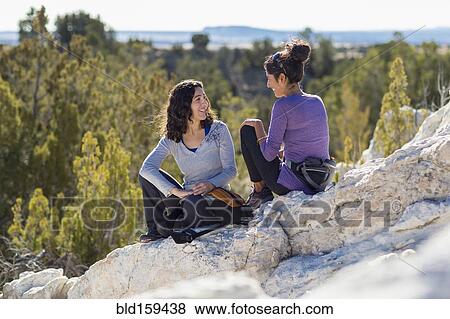Hikers talking on rocky hilltop View Large Photo Image Stock Photo - Hikers talking on rocky hilltop. Fotosearch