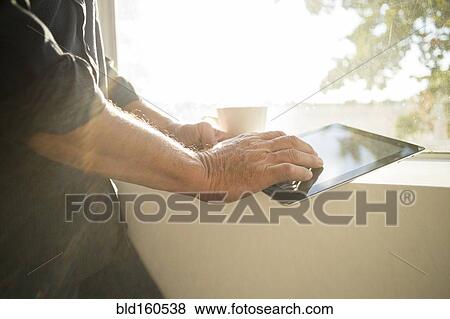 Hispanic businessman using digital tablet near window View Large Photo Image Stock Photo - Hispanic businessman using digital tablet near window. Fotosearch