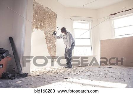 Hispanic construction worker demolishing wall View Large Photo Image Stock Image - Hispanic construction worker demolishing wall. Fotosearch