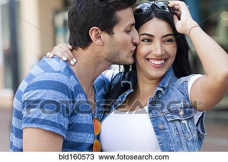 Stock Image - Hispanic couple kissing outdoors. Fotosearch