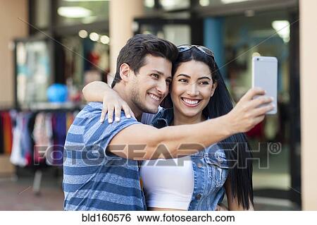Hispanic couple taking selfie outdoors View Large Photo Image Stock Photograph - Hispanic couple taking selfie outdoors. Fotosearch