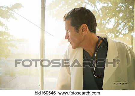 Stock Photograph - Hispanic doctor looking out window. Fotosearch
