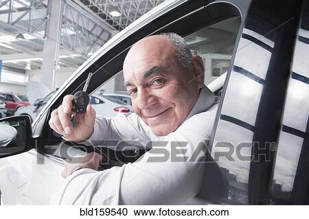 Stock Image - Hispanic man holding keys to new car. Fotosearch