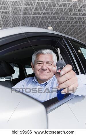 Stock Photograph - Hispanic man holding keys to new car. Fotosearch