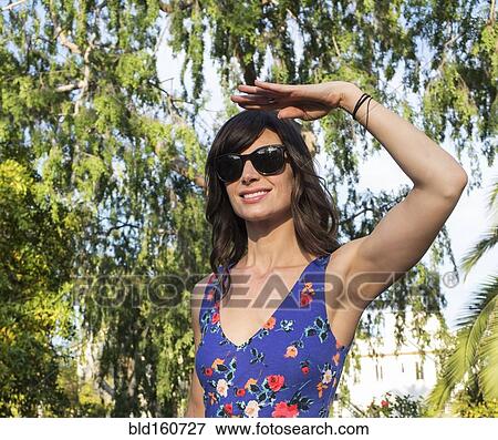 Hispanic woman shielding her eyes from sun View Large Photo Image Stock Photo - Hispanic woman shielding her eyes from sun. Fotosearch
