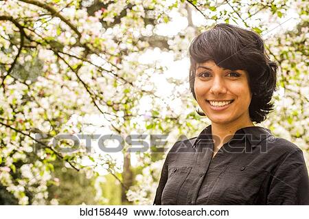 Hispanic woman smiling under trees View Large Photo Image Stock Photo - Hispanic woman smiling under trees. Fotosearch