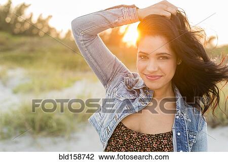 Stock Image - Hispanic woman standing on beach. Fotosearch