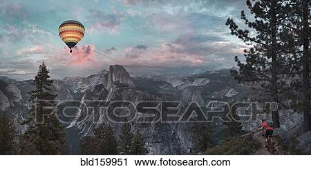 Stock Image - Hot air balloon floating over dramatic mountains, Richmond, Virginia, United States. Fotosearch