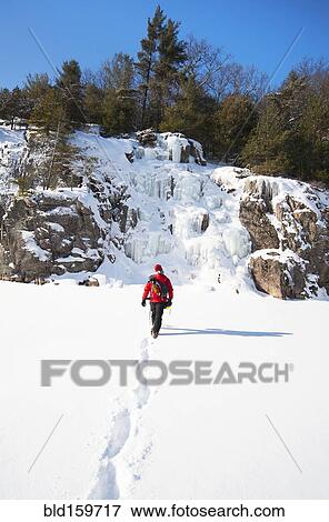 Ice climber walking toward frozen rock formations View Large Photo Image Stock Photo - Ice climber walking toward frozen rock formations. Fotosearch