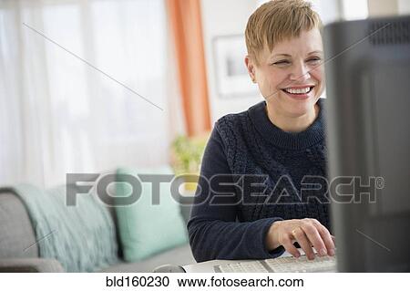 Laughing Caucasian woman using computer View Large Photo Image Stock Image - Laughing Caucasian woman using computer. Fotosearch