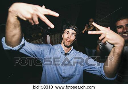 Stock Image - Laughing man dancing in nightclub. Fotosearch