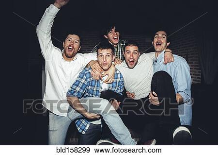 Stock Photo - Laughing men playing at party at night. Fotosearch