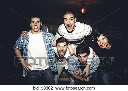 Stock Image - Laughing men posing at party at night. Fotosearch