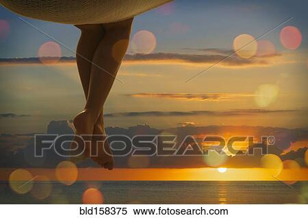 Legs of Caucasian woman sitting in hammock near ocean at sunset View Large Photo Image Stock Photography - Legs of Caucasian woman sitting in hammock near ocean at sunset. Fotosearch
