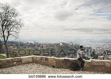 Stock Photograph - Man admiring scenic view of cityscape, Granada, Spain. Fotosearch