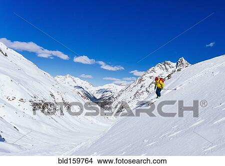 Picture - Man skiing on snowy slope in remote landscape. Fotosearch