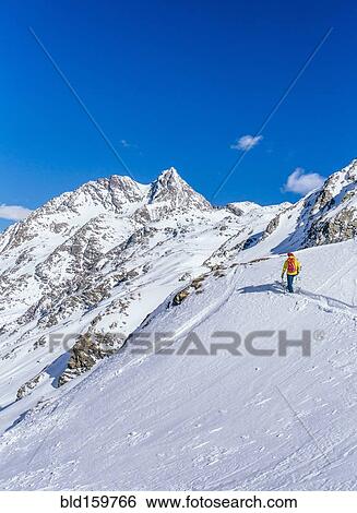 Stock Photograph - Man skiing on snowy slope in remote landscape. Fotosearch