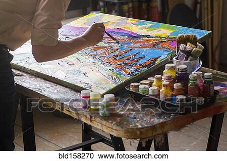 Stock Image - Mari artist painting canvas in studio. Fotosearch