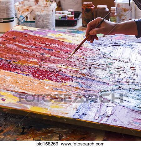 Stock Photo - Mari artist painting canvas in studio. Fotosearch