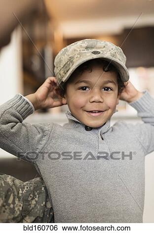 Stock Photograph - Mixed race boy wearing soldier cap. Fotosearch