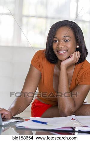 Picture - Mixed race businesswoman working at desk. Fotosearch