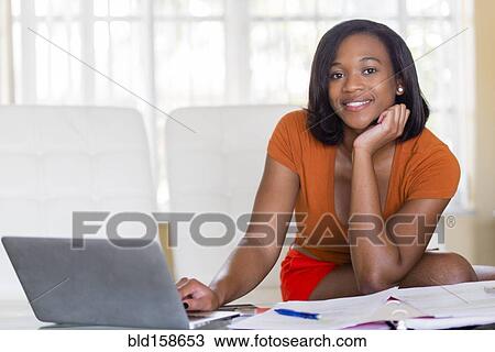 Mixed race businesswoman working at desk View Large Photo Image Stock Image - Mixed race businesswoman working at desk. Fotosearch