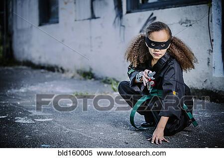 Stock Photography - Mixed race girl in martial arts uniform and mask. Fotosearch