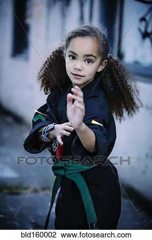 Stock Image - Mixed race girl practicing martial arts. Fotosearch