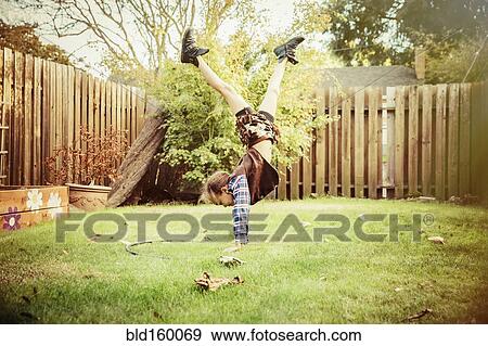 Stock Photo - Mixed race girl wearing cowboy costume in backyard. Fotosearch