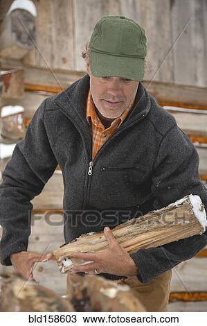 Mixed race man carrying firewood near snowy shed View Large Photo Image Stock Image - Mixed race man carrying firewood near snowy shed. Fotosearch