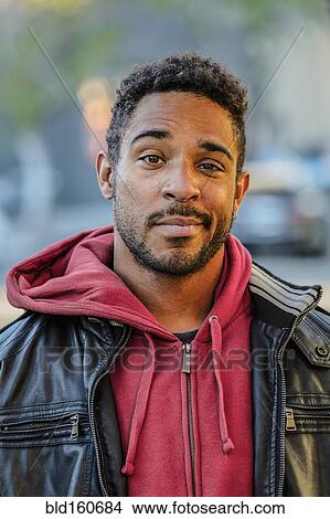Mixed race man with raised eyebrow standing outdoors View Large Photo Image Picture - Mixed race man with raised eyebrow standing outdoors. Fotosearch